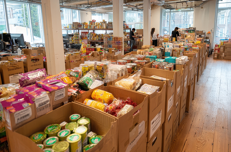 Food bank supplies in boxes on wooden floor