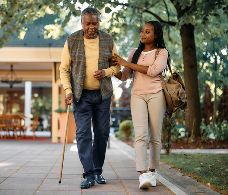 grandaughter walking with grandfather outside a nursing home