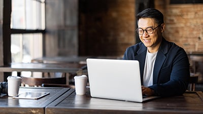 Businessman on laptop in cafe